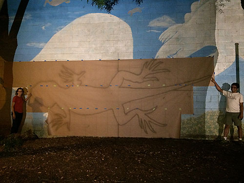 giant fence lizard projected onto paper to create stencil for street mural