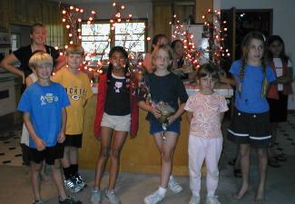 Holiday Craft project members posing with their Halloween lighted trees